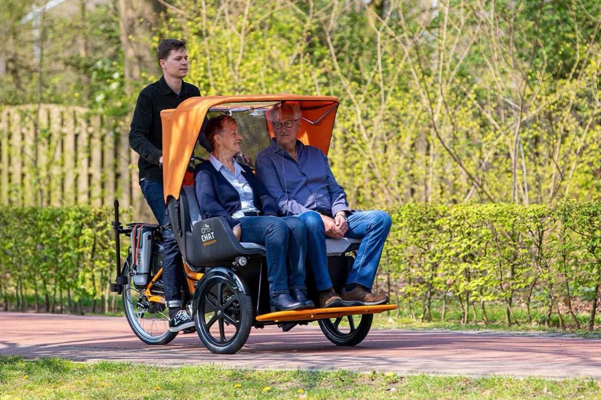 Passengers enjoy a scenic ride on the Chat Rickshaw Bike by Van Raam.